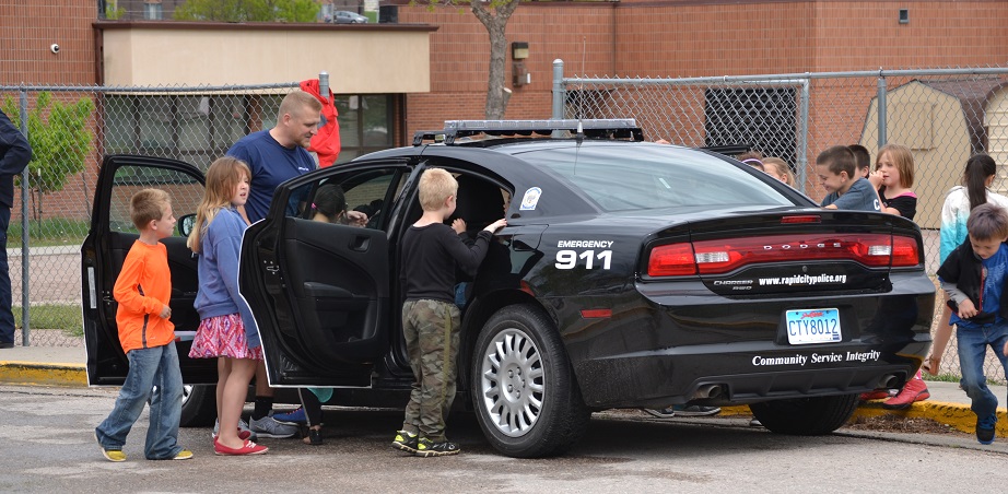 Officer Tim Doyle shows off his patrol car to students at Knollwood Elementary