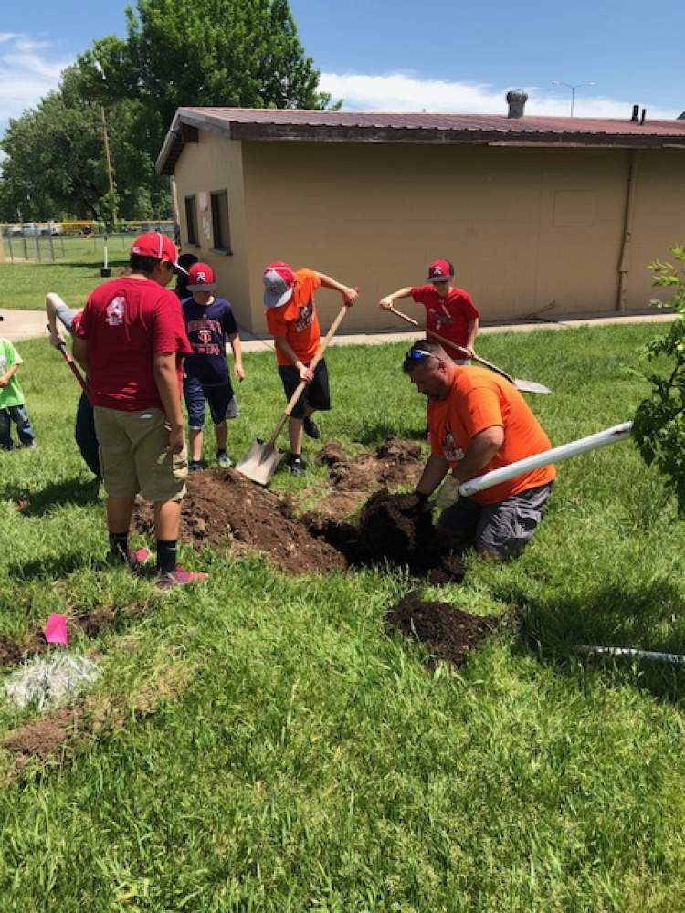 Rushmore Little League players and volunteers join with City Parks staff in planting 25 trees at the Rushmore Little League baseball complex as part of the 2018 Arbor Day project.
