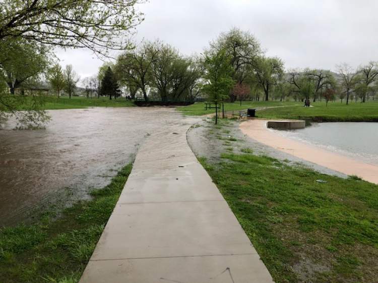Rapid Creek is over its banks and overflowing the bike path and into Memorial Pond near the Civic Center.   City officials advise no travel on the City's bike path due to flooding concerns.