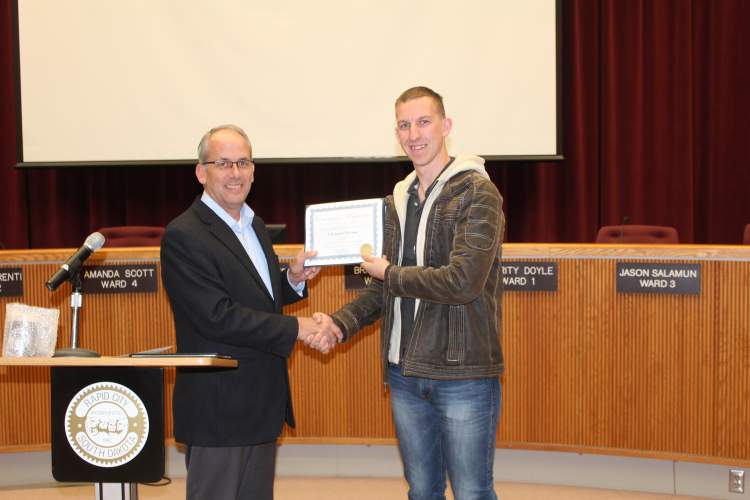 Staff Sgt. Christian Messina (right) receives recognition from Rapid City Mayor Steve Allender at the March 20 City Council meeting as Rapid City's Veteran of the Month for March.