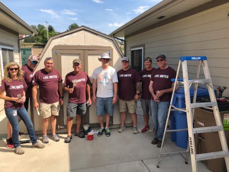 Rapid City Mayor Steve Allender and several department directors gather after painting one of three sheds at Black Hills Works locations as part of the kickoff to the Month of Caring activities for United Way of the Black Hills.