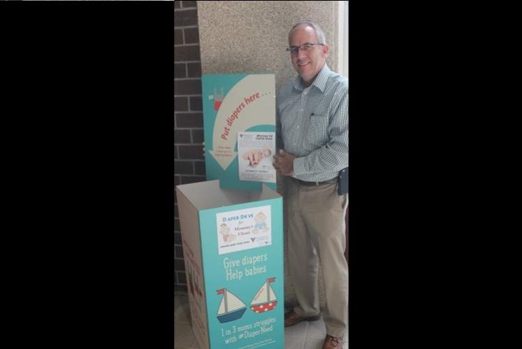 Mayor Steve Allender stands next to the Diaper Drop Box, a collection point for packaged and boxed diapers that will be placed in the lobby Sept. 25-Sept. 29 as part of Diaper Need Awareness Week collections.