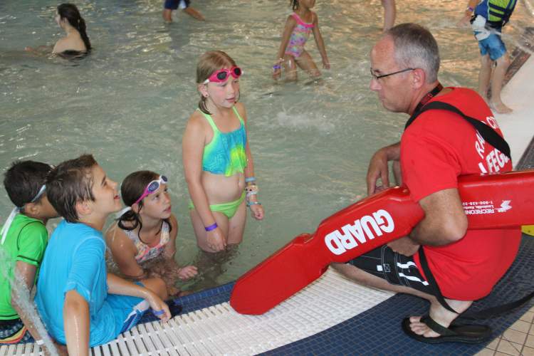Mayor Allender chats with swimmers at the Rapid City Swim Center.  The mayor was shadowing as a lifeguard, part of his job shadowing activities at City departments this summer.