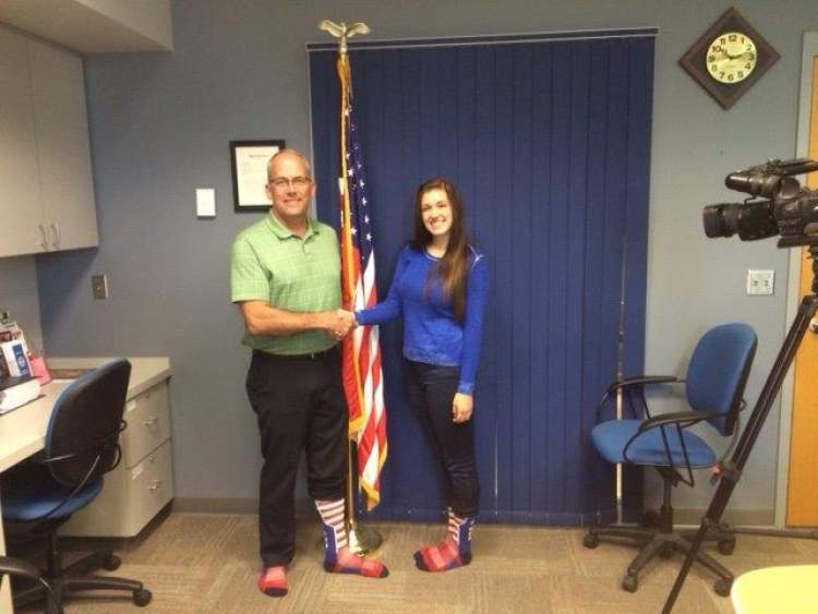 Mayor Steve Allender wears a pair of patriotic socks and greets promoter Jessica Benson, a sophomore at Rapid City Stevens. Benson is selling the socks as a way for the community to show unity in honor of 9/11 and to honor first responders.