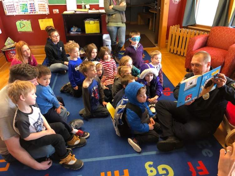 Assistant Police Chief Don Hedrick reads to YMCA children as part of Week of the Young Child activities.