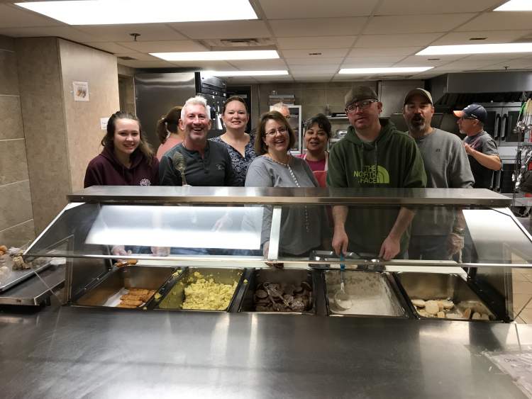Regional Airport staff prepare and serve meals monthly at the Mission, using the discarded pocket change from travelers for meals and care bags for residents.