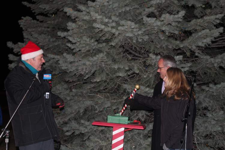Mayor Steve Allender and wife Shirley push the lever to light the Wilson Park Christmas tree as co-emcee Mike Modrick provides the countdown.